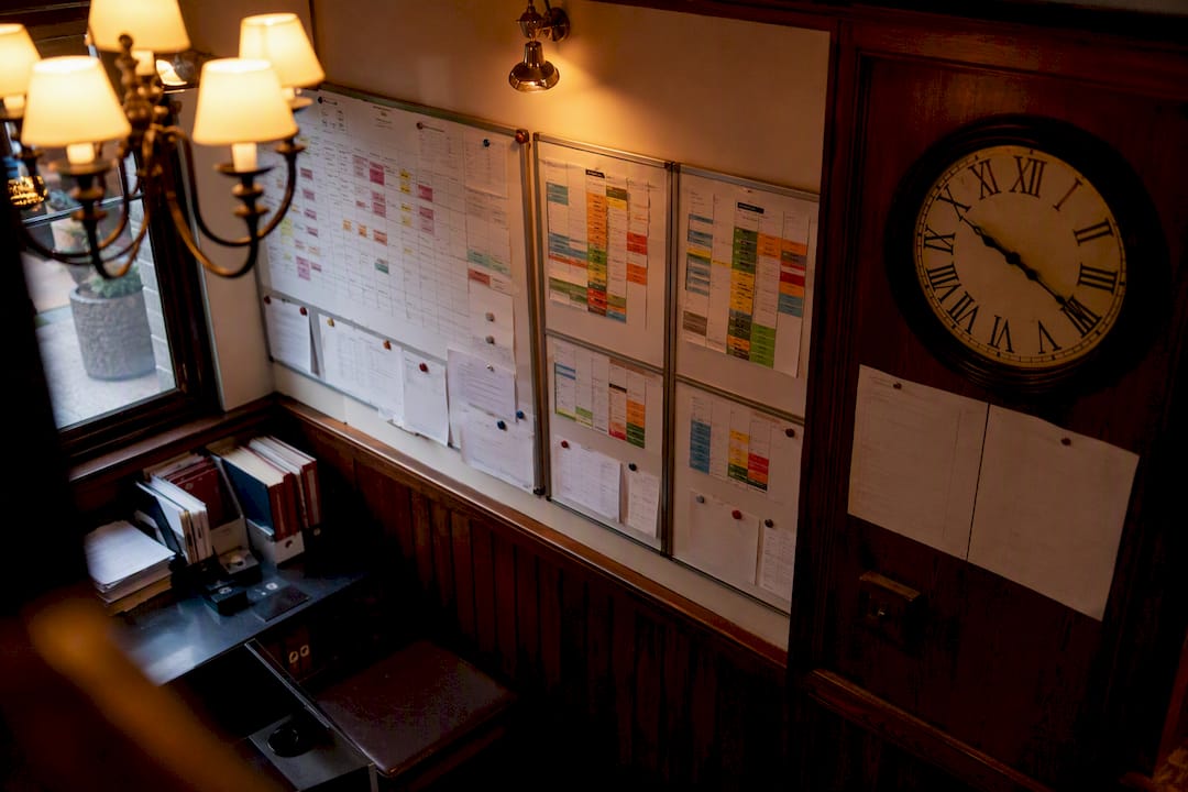 Orari dei turni analogici appesi alla parete dell'ufficio del pub