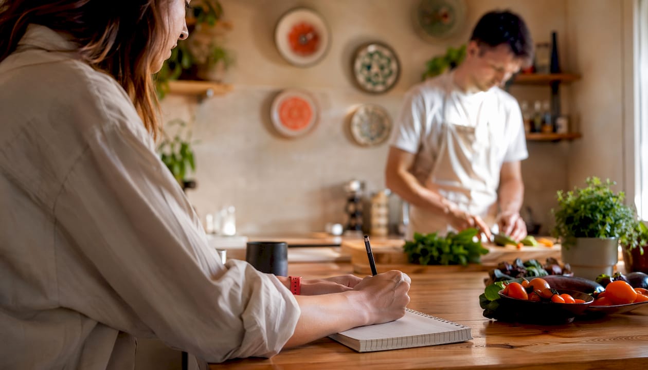 Le mani segnano il cambio dei piatti sulla lavagna della cucina.